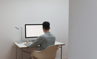 Student sits at a desk with a computer trying to articulate their personal story