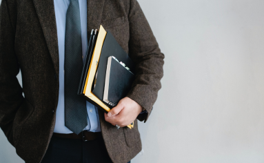 A man holding papers with the Top 10 Questions Asked of Admissions Directors
